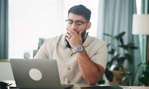Ragazzo che sbadiglia, mentre cerca al computer quando la stanchezza deve preoccupare